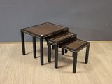 a set of three black nesting tables on a wooden floor