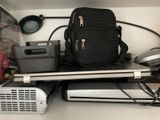 un sac à dos noir posé sur une étagère, à côté d'un ordinateur portable
