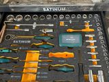 Quelqu'un tient une boîte à outils remplie d'outils dans un garage.