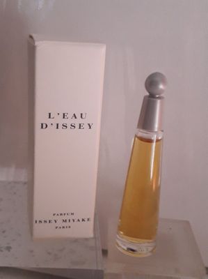 un flacon de parfum posé sur une table à côté d'une boîte
