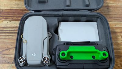 a green and black case with a knife and other items in it