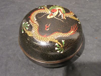 une boîte noire ornée d'un dragon, posée sur une table