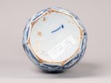 a blue and white vase with a face on it