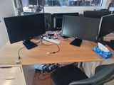 a desk with three computer monitors and a keyboard on it
