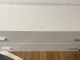une commode blanche posée sur un parquet, dans une pièce