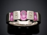a close up of a pink sapphire and diamond ring