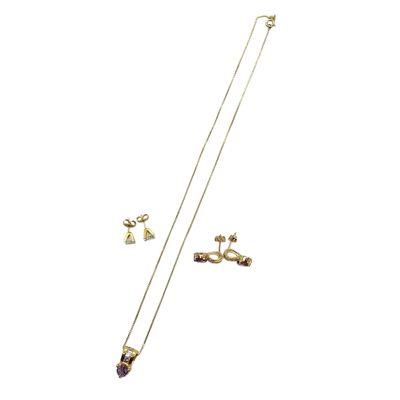 a close up of a necklace and earring on a white background