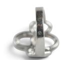 a silver ring with a diamond in it on a white surface