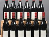 six bottles of red wine in a wooden crate on a table