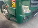 a green truck that is parked on the side of the road