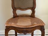 a wooden chair with a wicker seat on the floor