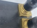 pair of black and gold candlesticks in the style of person