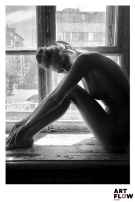 photographie en noir et blanc d'une femme nue assise sur un rebord de fenêtre