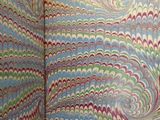 a bathroom with a toilet and a colorful wallpaper
