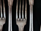 four forks that are sitting next to each other on a table