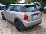 a silver mini cooper parked in a lot next to other cars