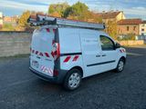 une camionnette blanche garée sur un parking, avec une échelle sur le toit