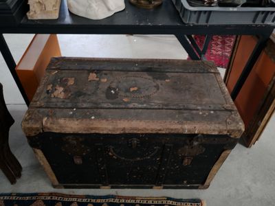 une vieille malle posée sur une table dans une pièce