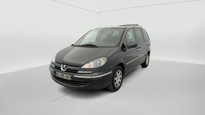 La camionnette noire est garée dans une pièce blanche au sol blanc.