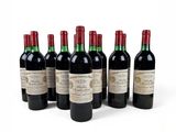six bottles of wine are lined up on a white surface
