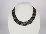 a black and silver beaded necklace on a white mannequin