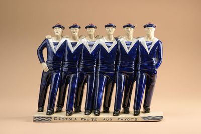 figurines en céramique bleues et blanches représentant des hommes vêtus de tenues de marin