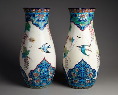 une paire de vases ornés d'oiseaux et de fleurs sur fond gris