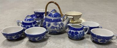 un service à thé bleu et blanc comprenant des tasses et un panier