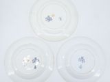 three white plates with blue and white designs on them on a white surface