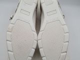 a pair of white sneakers on top of a box on a white surface