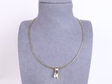a silver necklace with a cat pendant on a mannequin neck