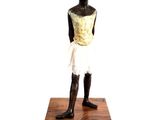 statue of a young boy standing on a wooden base