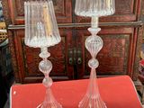une paire de lampes de table en verre transparent posées sur une table rouge devant une armoire rouge