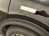 a man that is painting a car with a sticker on it