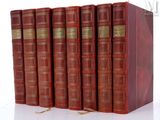 six red books are lined up in a row on a white surface