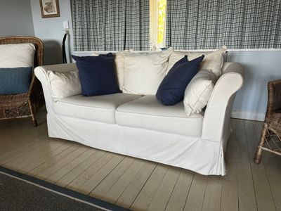 a white couch with blue pillows on it in a living room