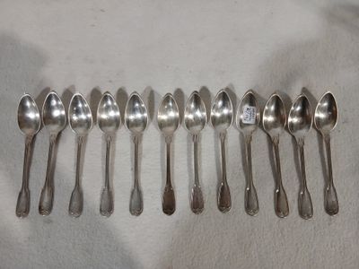 six cuillères en argent sont alignées sur une table