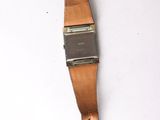 an old watch with a leather strap hanging on a wall