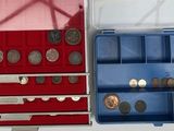 deux boîtes remplies de pièces de monnaie posées sur une surface blanche