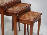 three wooden tables with wicker tops on them