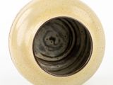 a white vase with a black swirl inside of it
