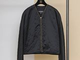 une veste noire suspendue à un portant dans une pièce