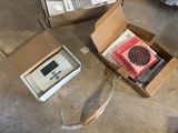 two boxes of electronic devices on the floor next to each other