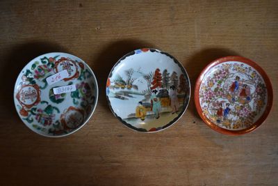 three plates are sitting on a wooden table with a tag on them