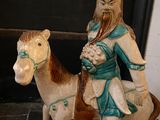 a figurine of a man riding a horse on the ground