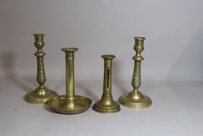 three brass candlesticks are sitting on a white surface