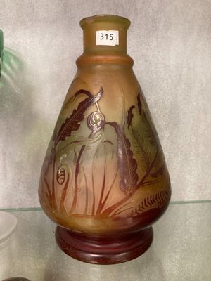 a vase with a picture of a woman on it on a glass shelf