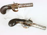 une paire de pistolets anciens exposés sur un support blanc