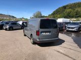 many cars parked in a parking lot with mountains in the background