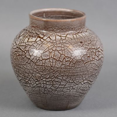 a brown vase that has a cracky surface on it